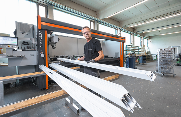 Mitarbeiter bearbeitet Metallschienen